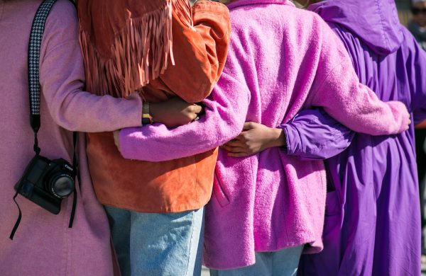 four person holding each others waist at daytime